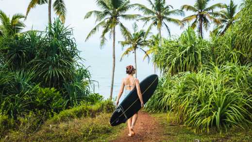 Une surfeuse porte un longboard