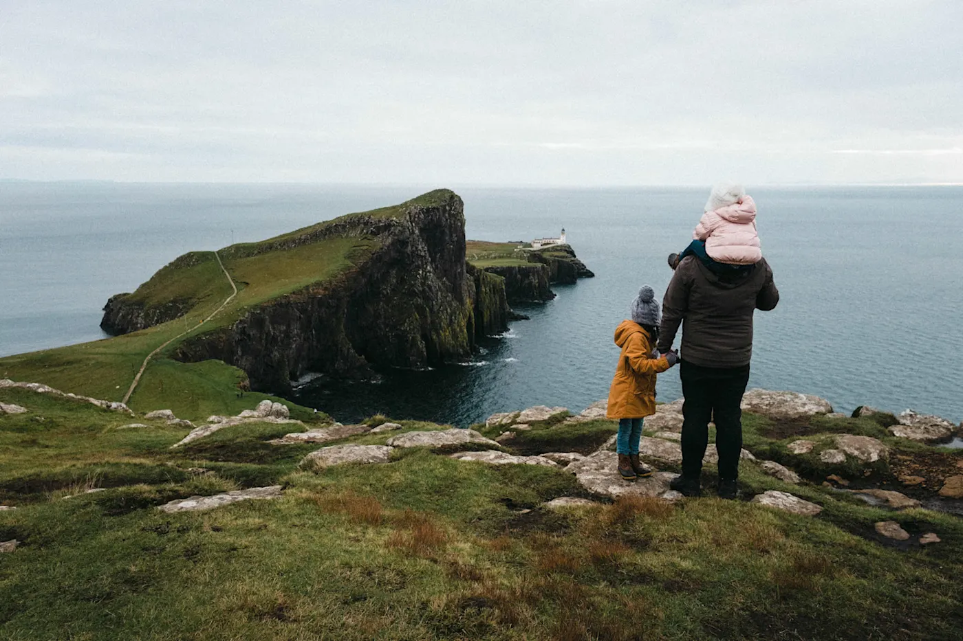 Mother and son in the Scottish Highlands on a family vacation looking out to sea at sunset