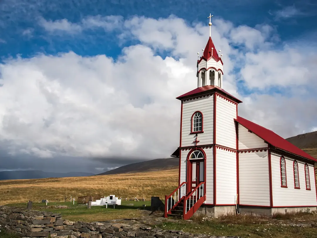 Island, Norðurland, Akureyri, Holzkirche Historische Holzkirche mit rotem Dach auf einer Wiese. Akureyri, Norðurland, Island.