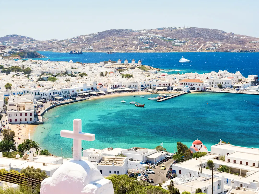 Blick auf die weiße Stadt Mykonos mit einem Kreuz im Vordergrund. Mykonos, Kykladen, Griechenland.