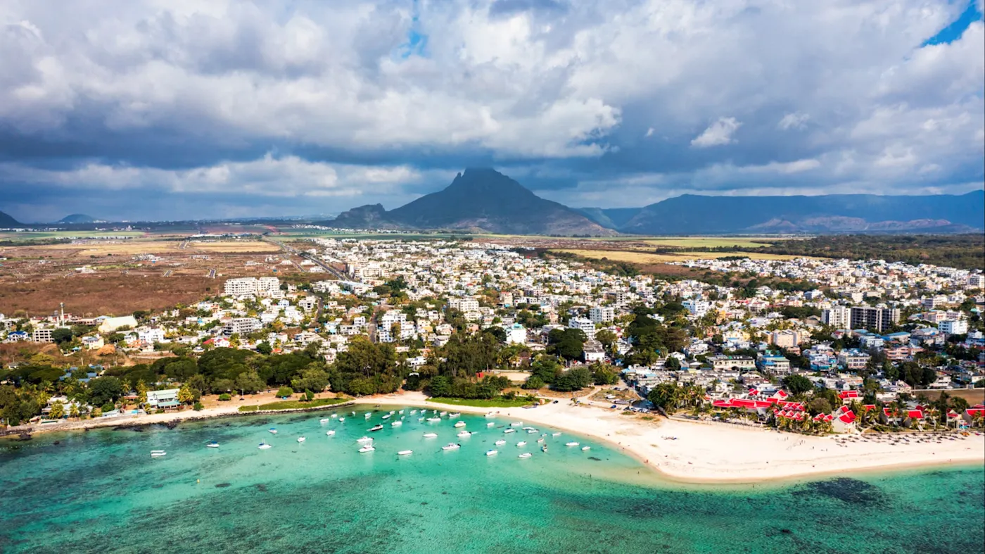 Flic en Flac, Mauritius Luftaufnahme von Strand und Stadt mit Bergen im Hintergrund. Flic en Flac, Mauritius.