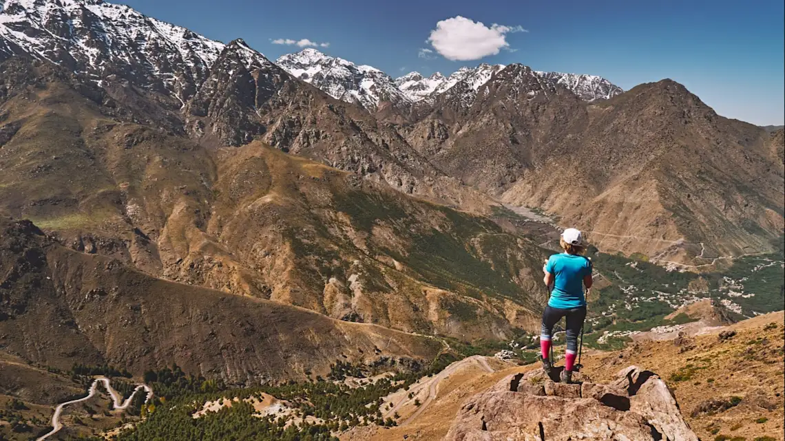 Frau mit Blick auf schneebedeckte Gipfel des Hohen Atlas in Marokko Afrika.

