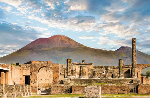 Antike Mauern in Pompeji mit dem Vulkan Vesuv im Hintergrund.