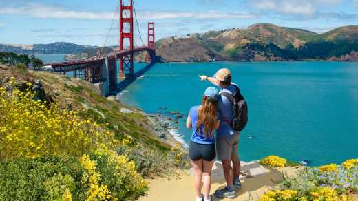 Paar zeigt auf die Golden Gate Bridge während einer Flitterwochenreise