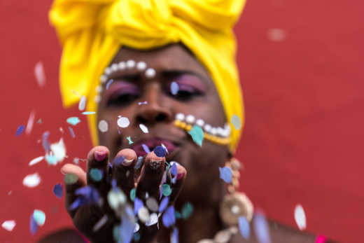 Femme soufflant sur de confettis pendant le carnaval de Mombasa au Kenya.