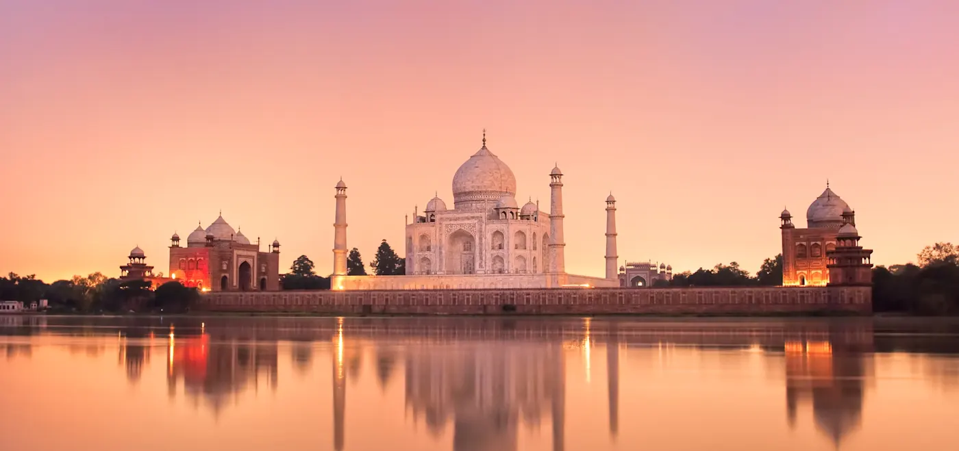 Agra, Uttar Pradesh, Indien Das Taj Mahal bei Sonnenuntergang spiegelt sich im Wasser des Yamuna-Flusses. Agra, Uttar Pradesh, Indien.
