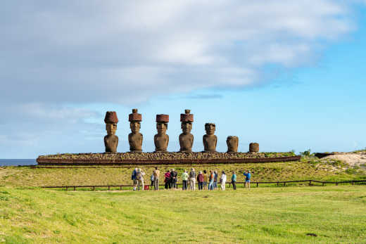 A Group of Tourists are watching Moai statues of Ahu Nau Nau on Easter Island in Chile