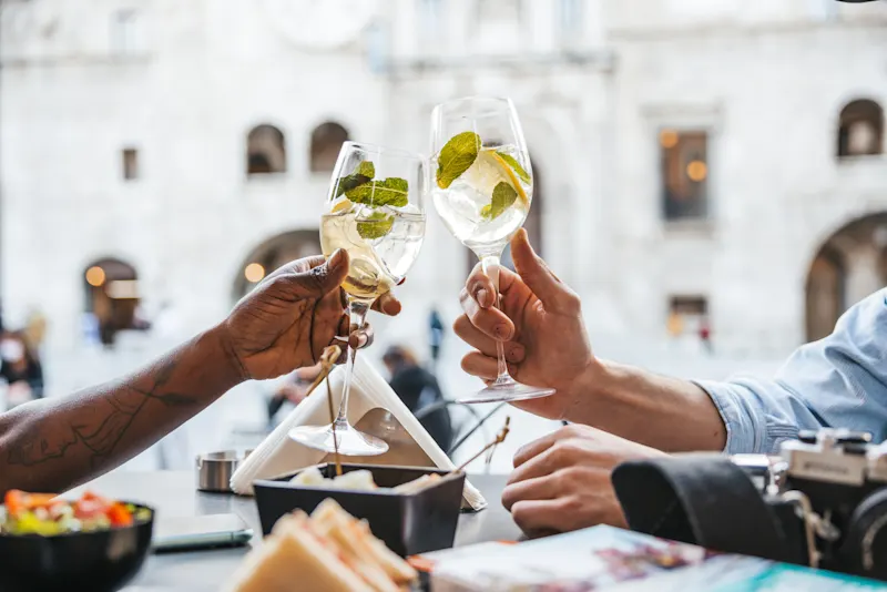 Italien, Kulinariktour Touristenpaar sitzt in einem Café und nimmt einen Aperitif zur Happy Hour, Italien.