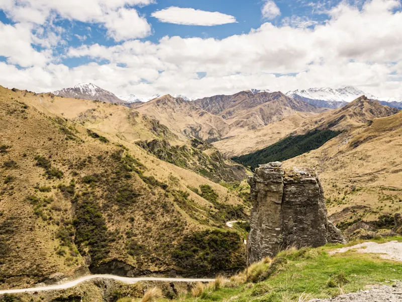 Queenstown, Otago, Neuseeland Schroffe Berglandschaft mit kurviger Straße und markantem Felsen. Queenstown, Otago, Neuseeland.