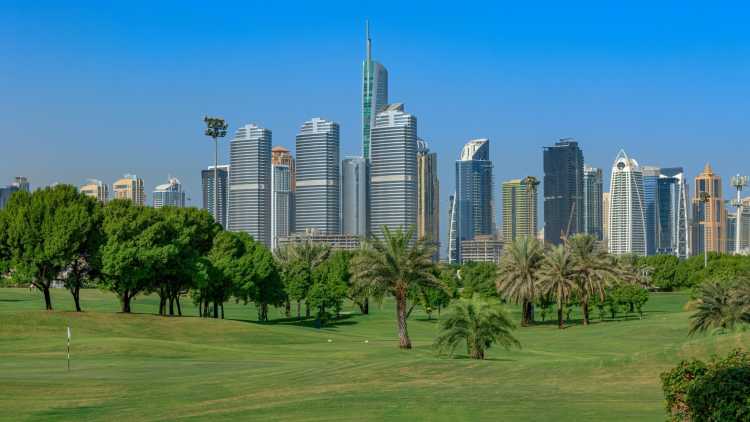 Panorama der Golf-Fairways und Wolkenkratzer der Jumeirah Lake Towers, Dubai, Vereinigte Arabische Emirate.