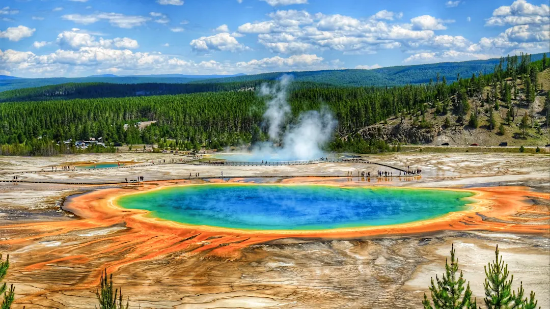 Grand Prismatic Spring mit bunten Farben und dampfenden Geysiren. Yellowstone, Wyoming, USA.