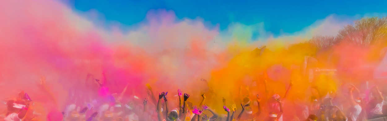 Crowd in the cloud of bright coloured powder at the Holi Dahan Festival.