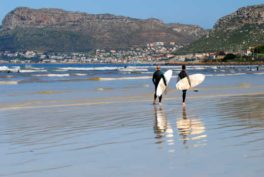 Deux surfeurs sur une plage du Cap en Afrique du Sud.