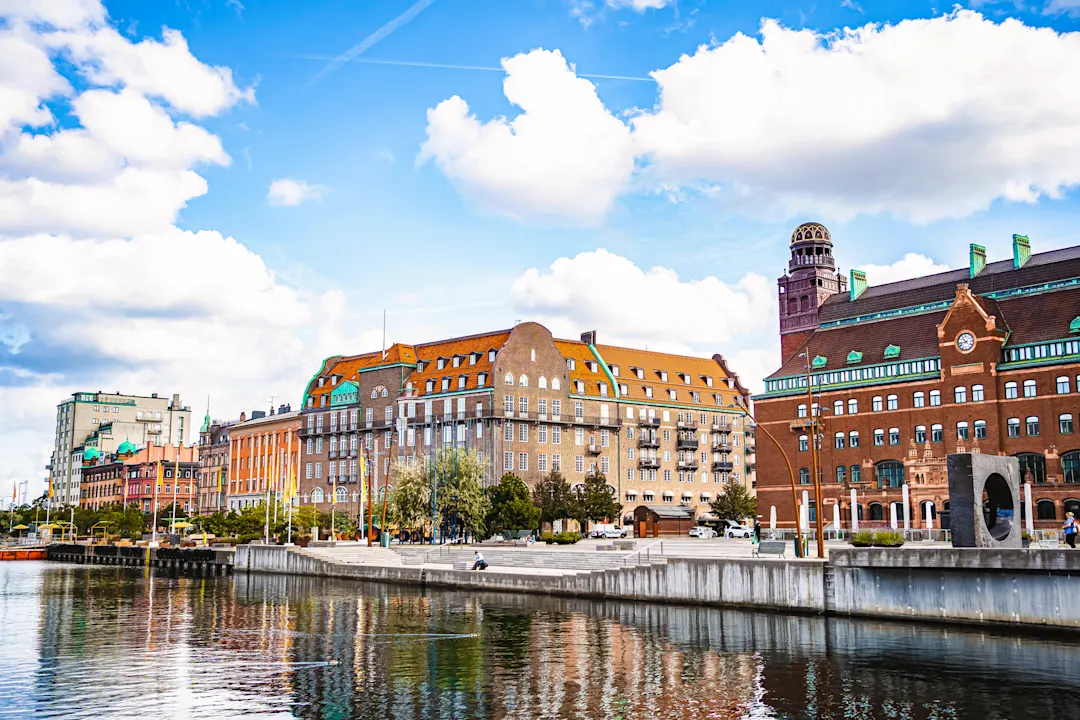 Das Stadtbild von Malmö spiegelt sich bei bewölktem Himmel im Kanal wider