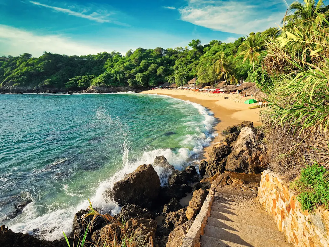 Tropischer Strand mit grüner Bucht. Mazunte, Oaxaca, Mexiko.
