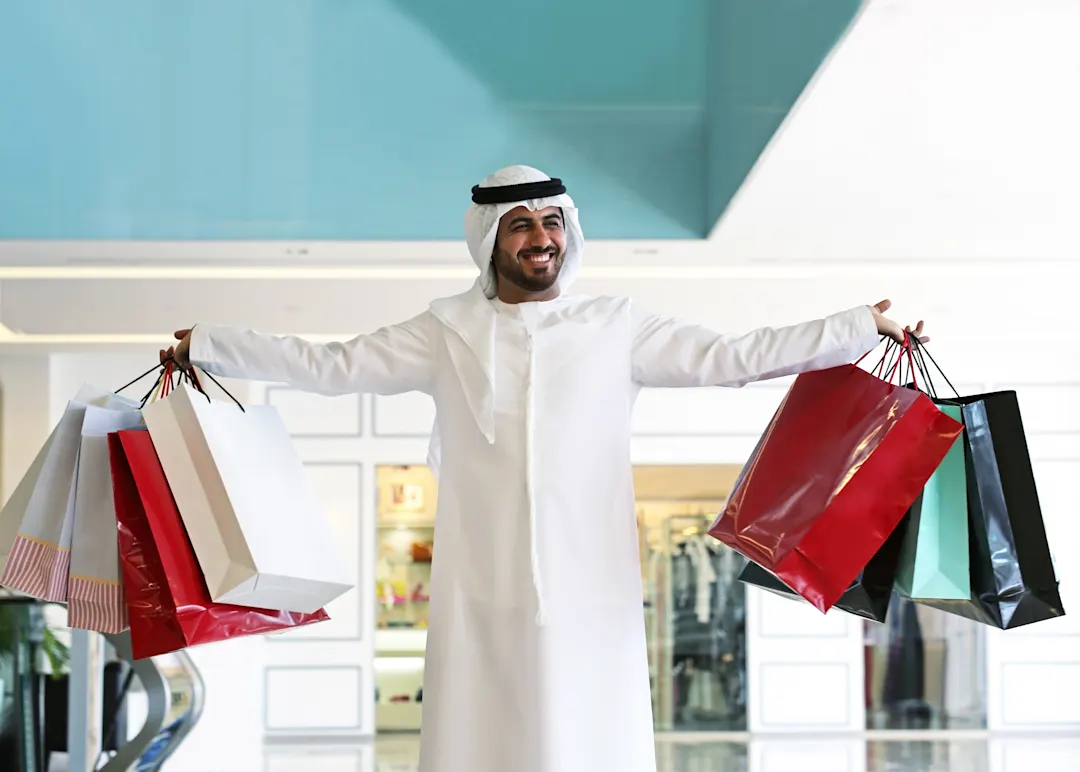Saudi-Arabien, Einkaufszentrum Arabischer Mann im Einkaufszentrum mit Taschen