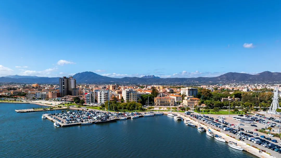 Hafenansicht von Olbia mit Stadt, Booten und Bergen im Hintergrund, Olbia, Sardinien, Italien.
