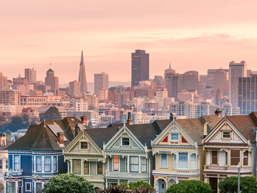 Painted Ladies mit Skyline bei Sonnenuntergang, San Francisco, Kalifornien, USA.
