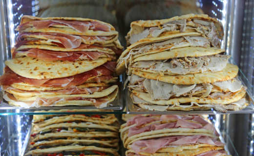 Probieren Sie die Piadina, eine Art lokales Sandwich, während des Rimini Street Food Festivals während Ihrer Reise.