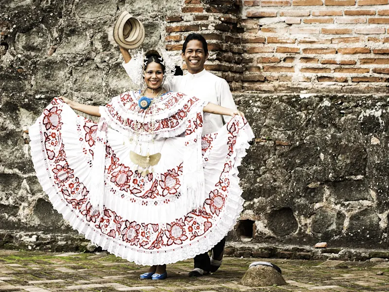 Traditionelle Kleidung vor einer historischen Mauer. Las Tablas, Los Santos, Panama.