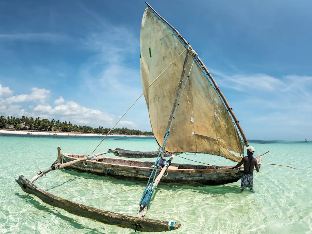 Fischer mit traditioneller Dhow im türkisfarbenen Wasser nahe der Küste. Lamu Island, Lamu, Kenia.