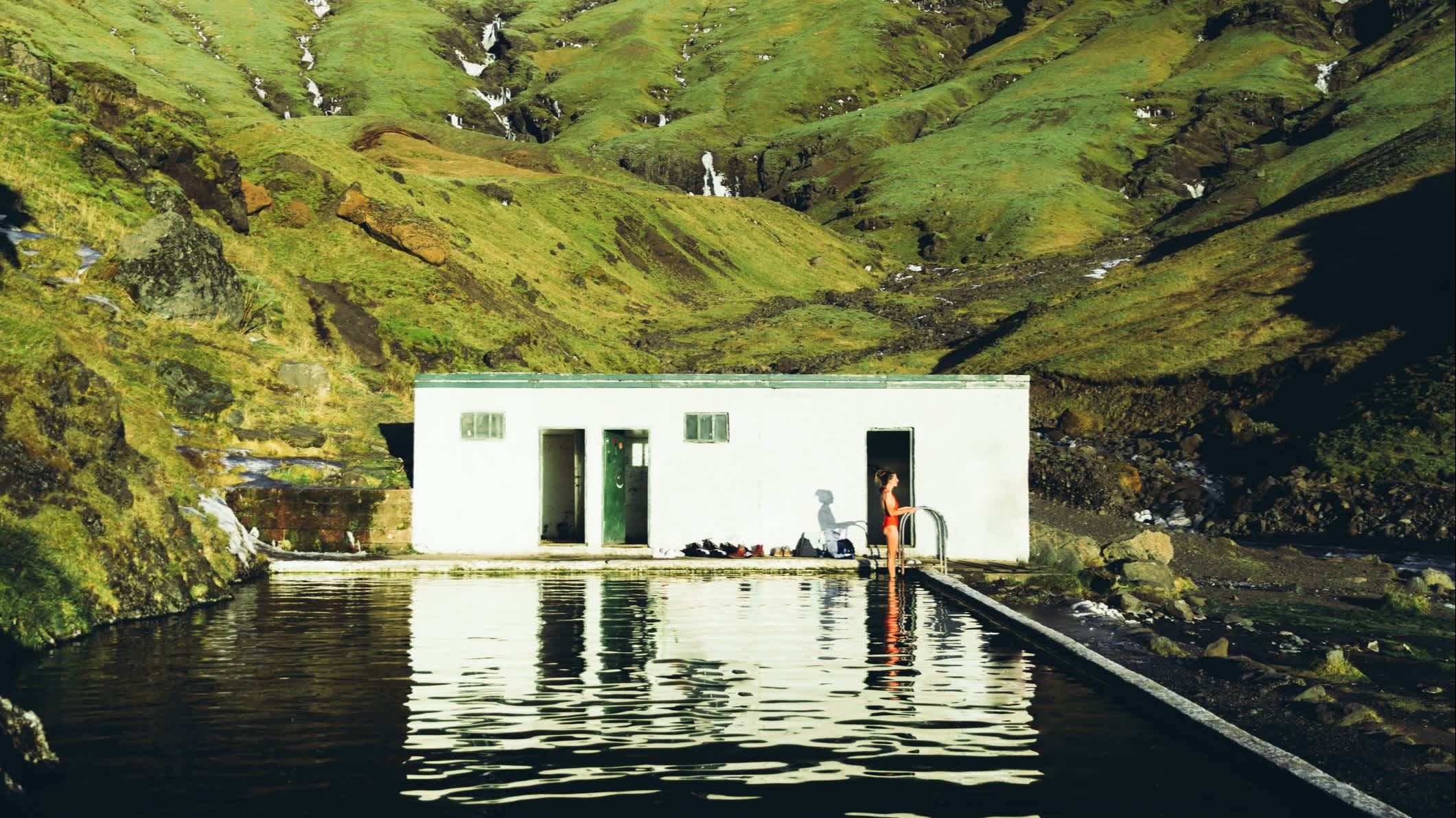 Une femme se baigne dans une piscine naturelle chaude Seljavallalaug en Islande