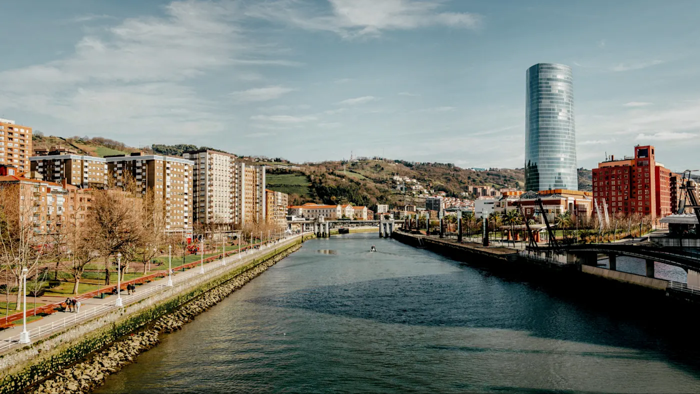 Blick auf den Nervión-Fluss mit modernen Gebäuden und Grünflächen. Bilbao, Baskenland, Spanien.