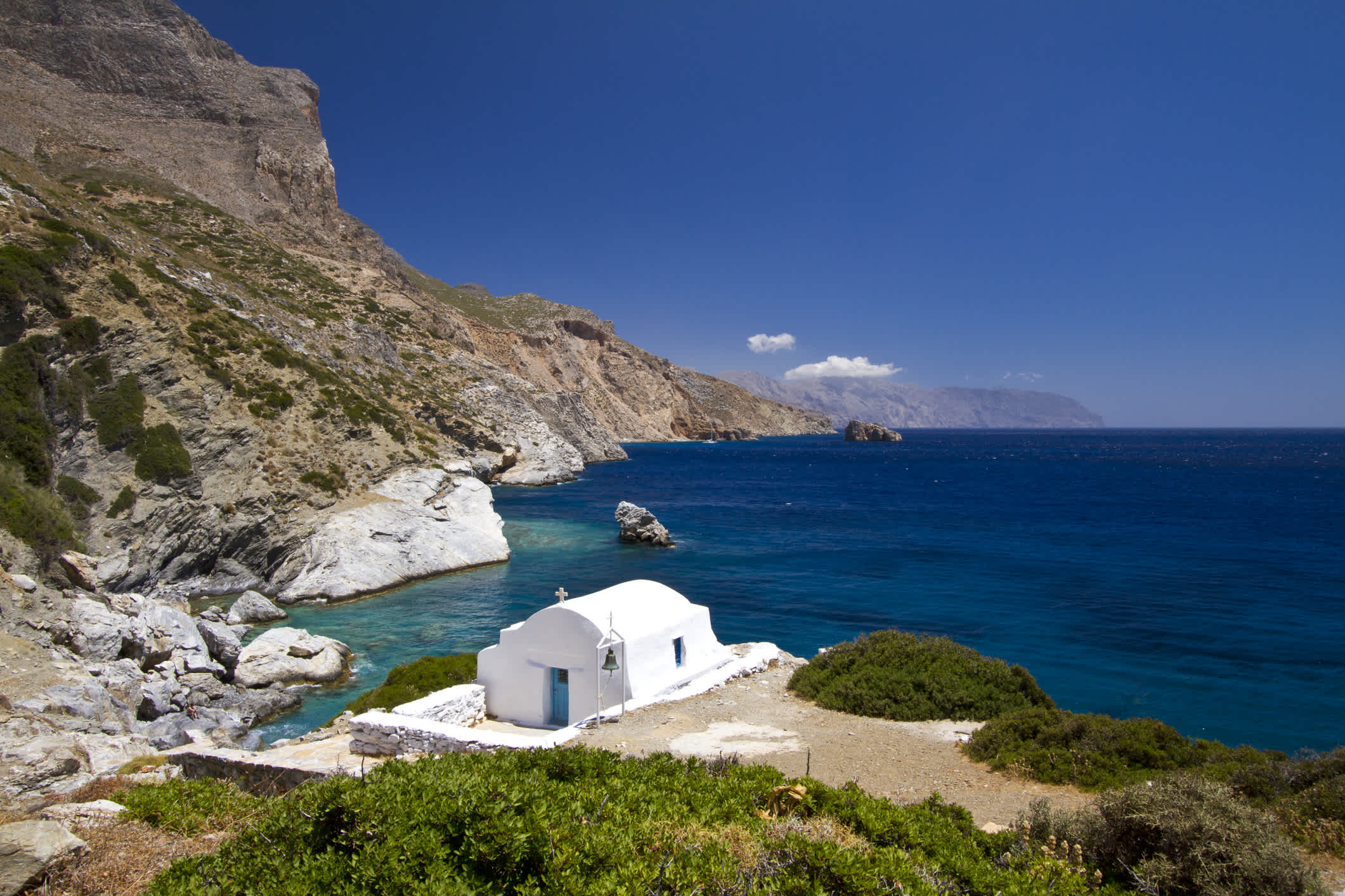 Idyllische Küste von Amorgos, auf den Kykladen in Griechenland, mit einer kleinen Kapelle, die die Küste bewacht.