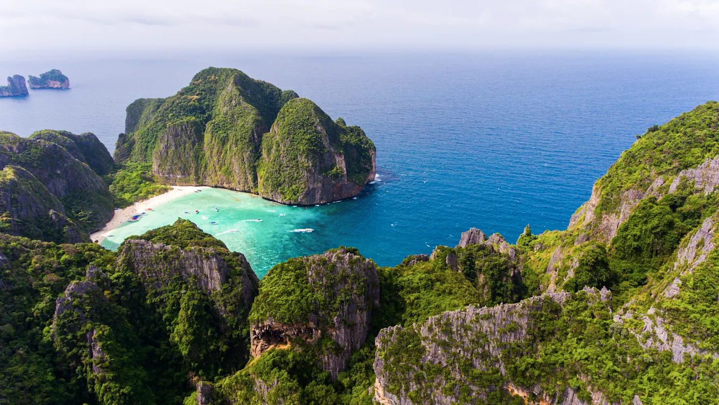 Koh Phi Phi, Thailand Luftaufnahme einer türkisblauen Bucht mit steilen, bewaldeten Felsen. Koh Phi Phi, Thailand.