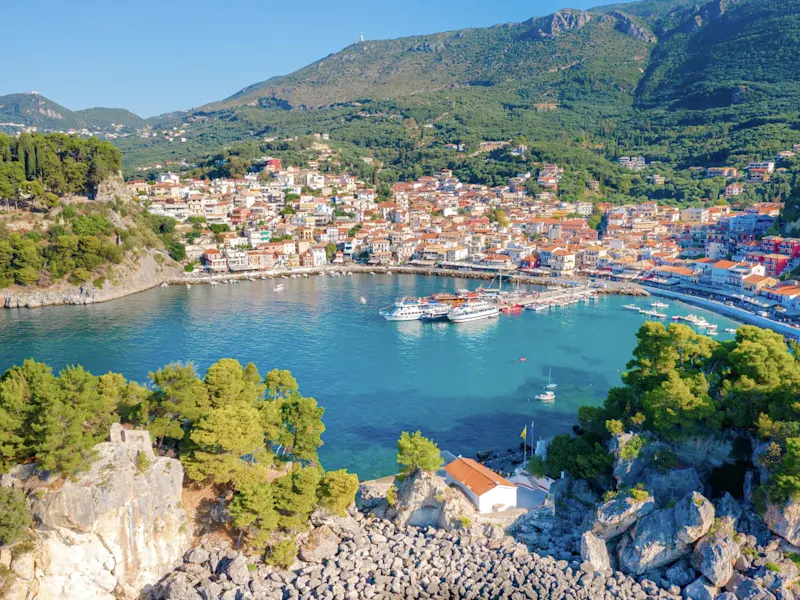 Colorful buildings, marina and green hills by the sea. Parga, Greece.