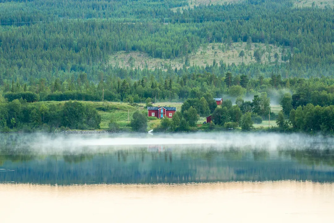Altes Chalet an einem See im Nebel, Schweden