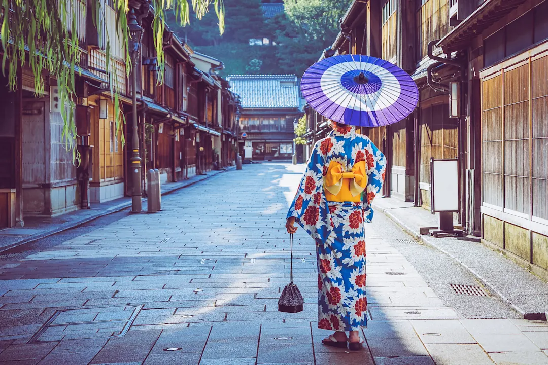 Frau in einem Kimono beim Spaziergang im Stadtteil Higashi Chaya in Kanazawa, Japan.

