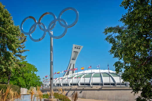 L'extérieur du stade olympique de Montréal entouré de différent drapeaux. Conçu par l'architecte Roger Tallibert, le stade est un des monuments à découvrir pendant votre voyage à Montréal.
