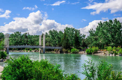 A bridge that crosses a river in the Prince's Island Park of Calgary