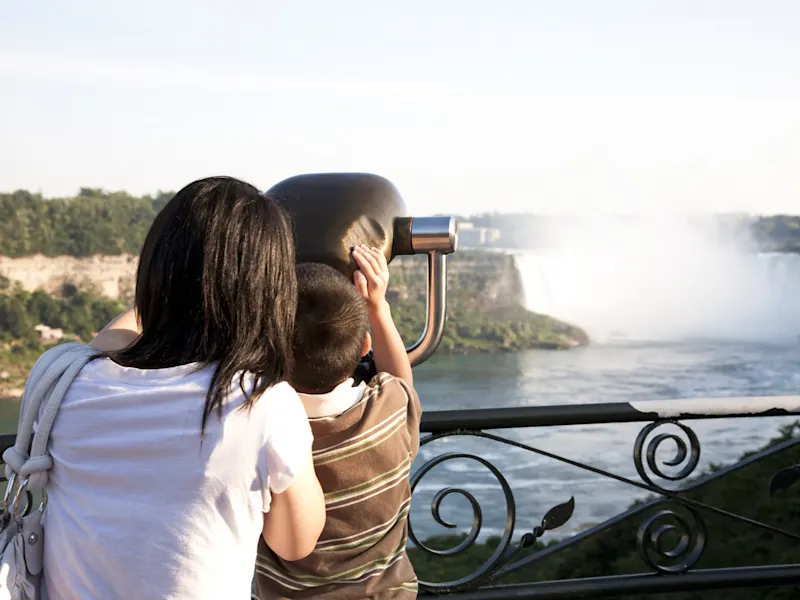 Niagarafälle, Ontario, Kanada Eine Frau und ein Kind betrachten die Niagarafälle durch ein Fernglas. Niagarafälle, Ontario, Kanada.