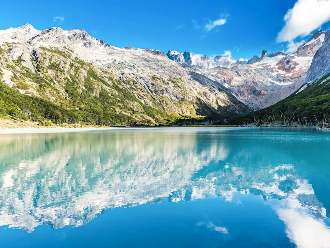 Smaragdgrüner Bergsee mit Spiegelung schneebedeckter Gipfel. Ushuaia, Tierra del Fuego, Argentinien.
