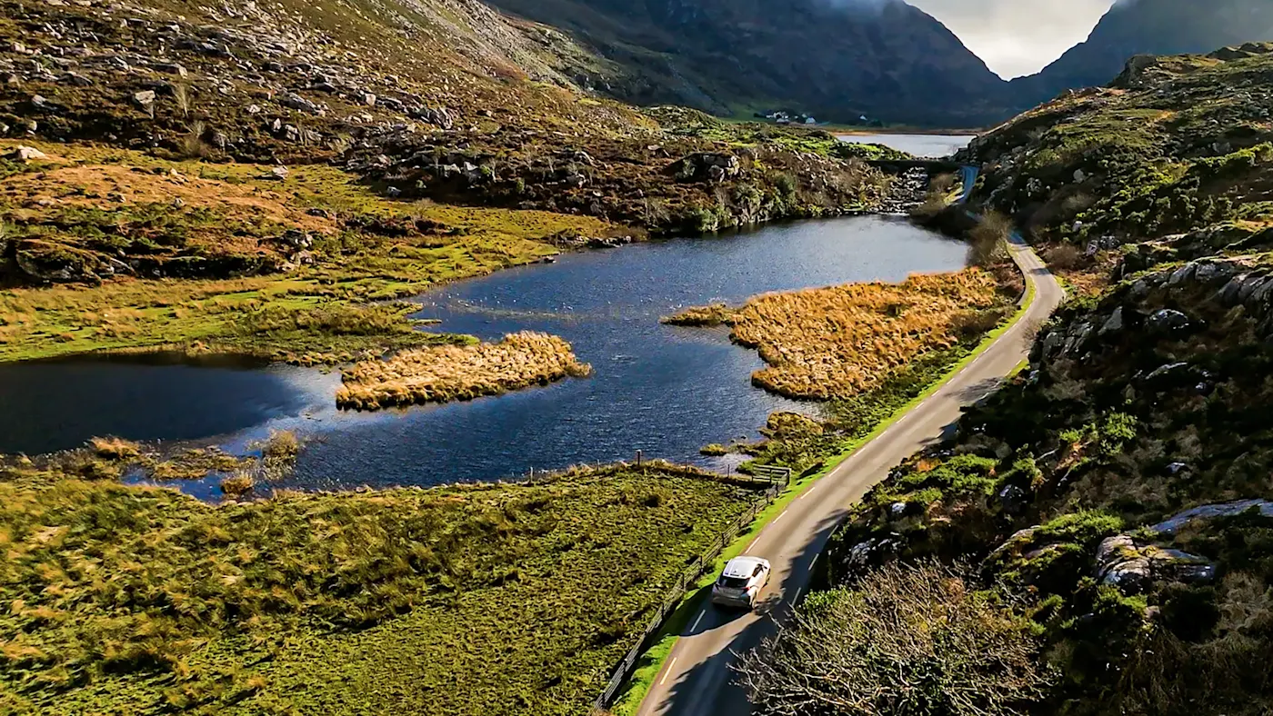 Irlande, Gap of Dunloe, Kerry, road trip Une autoroute sinueuse entre les montagnes et au bord d'une rivière. Gap of Dunloe, County Kerry, Irland.