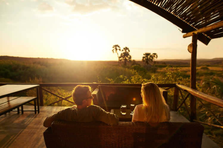 Paar auf der Terasse einer Lodge während einer Flitterwochenreise in Botswana