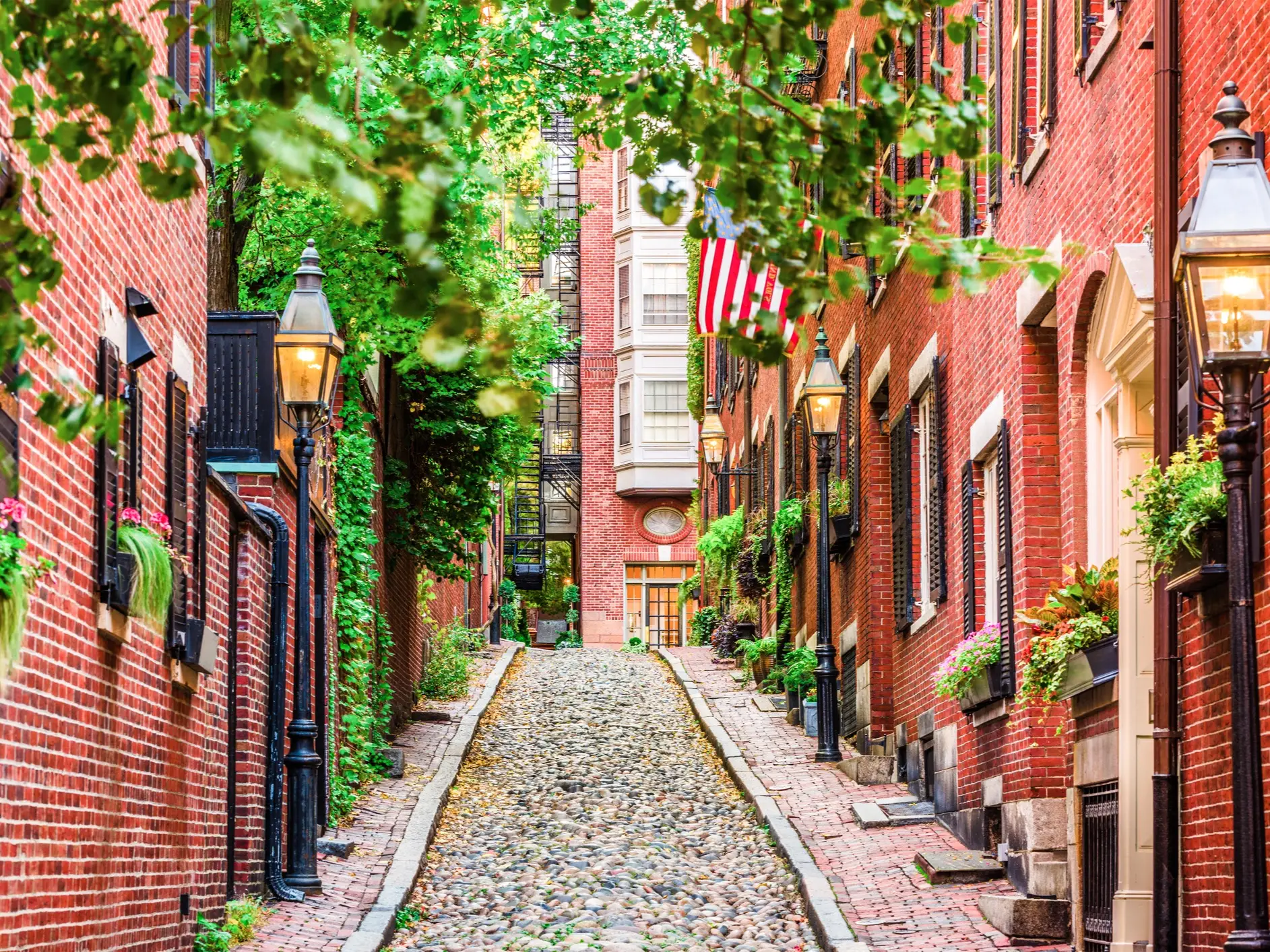 Historische gepflasterte Gasse mit roten Backsteinhäusern und Pflanzen. Boston, Massachusetts, USA.