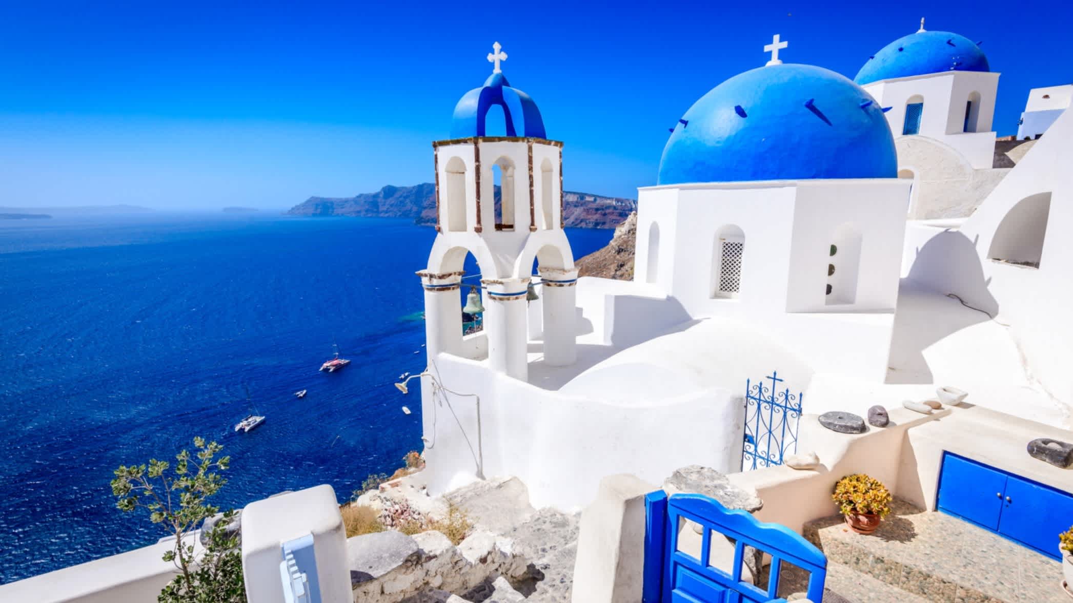Die Insel Santorin, Griechenland. Oia Stadt traditionelle weiße H�äuser und Kirchen mit blauen Kuppeln über der Caldera, Ägäis.
