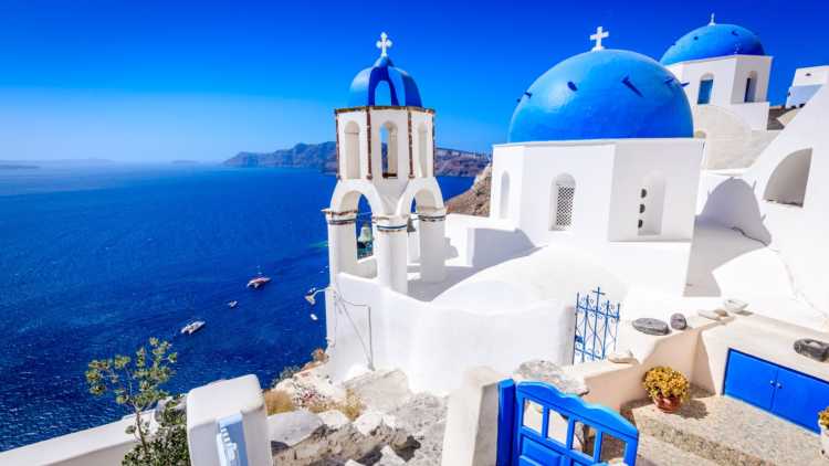Die Insel Santorin, Griechenland. Oia Stadt traditionelle weiße Häuser und Kirchen mit blauen Kuppeln über der Caldera, Ägäis.
