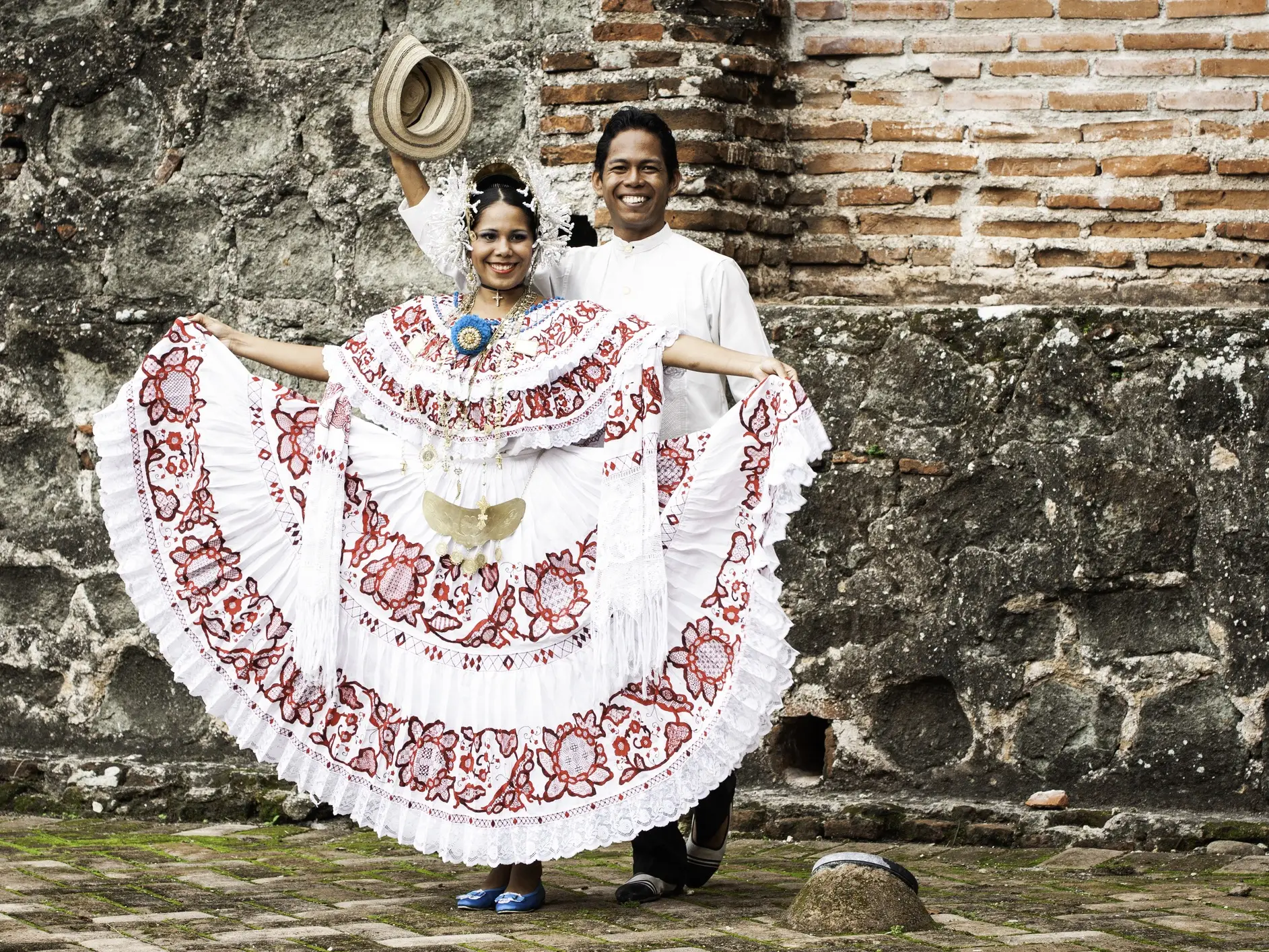 Traditionell gekleidetes Paar in folkloristischer Kleidung vor einer historischen Wand. Panama-Stadt, Panamá, Panama.