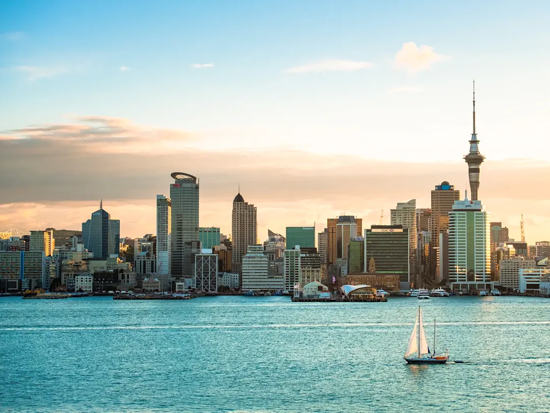 Skyline mit Segelboot bei Sonnenuntergang. Auckland, Auckland, Neuseeland.