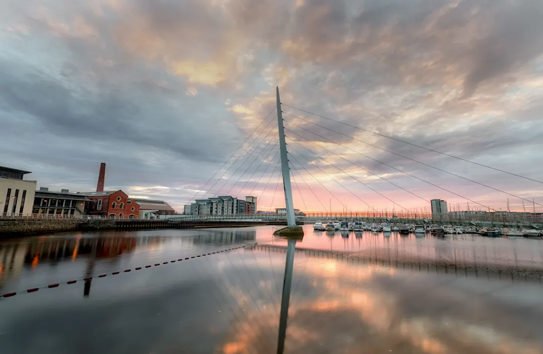 Sonnenaufgang an der Millennium Bridge über den Fluss Tawe in Swansea, Wales, Großbritannien.

