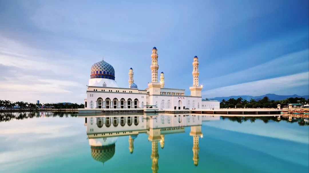 Schwimmende Moschee mit Spiegelung im Wasser bei Dämmerung. Kota Kinabalu, Sabah, Malaysia.
