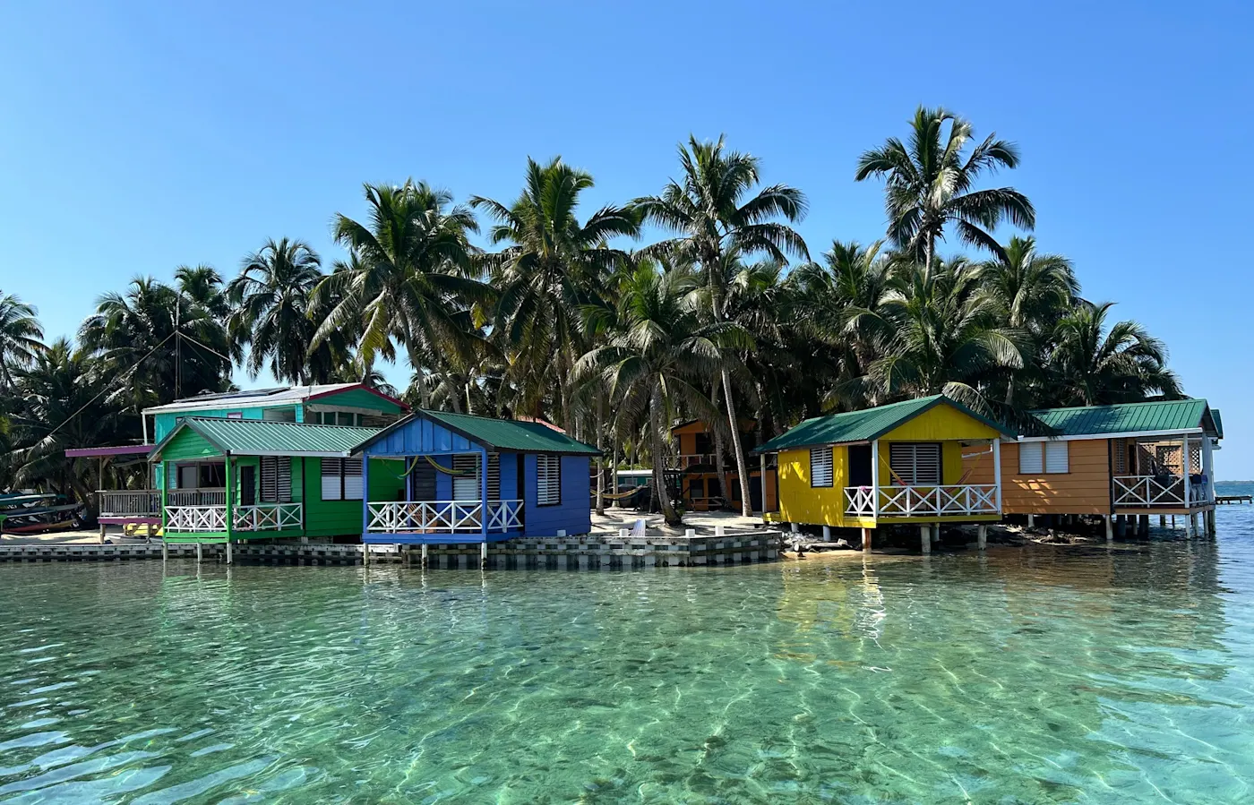 Belize, Strand mit Palmen Ein Strand mit Palmen und einem Holzsteg im Hintergrund, Belize.