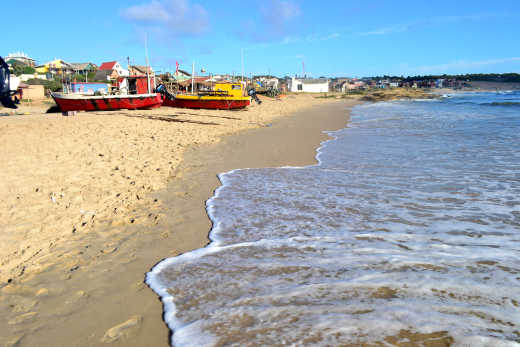Bateaux sur le sable et vagues sur la Playa de los Pescadores, Punta del Diablo, Uruguay