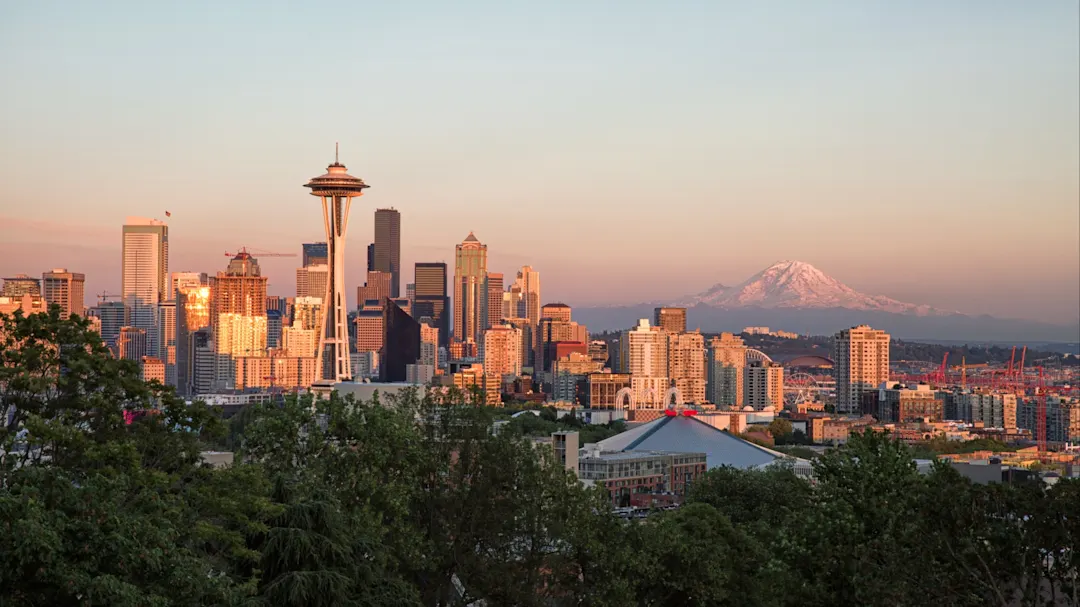 Skyline von Seattle bei Sonnenuntergang mit der Space Needle und Mount Rainier im Hintergrund. Seattle, Washington, Vereinigte Staaten.