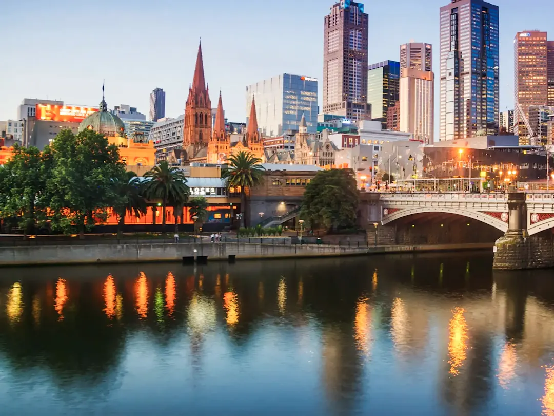 Fluss mit beleuchteter Skyline bei Dämmerung. Melbourne, Victoria, Australien.
