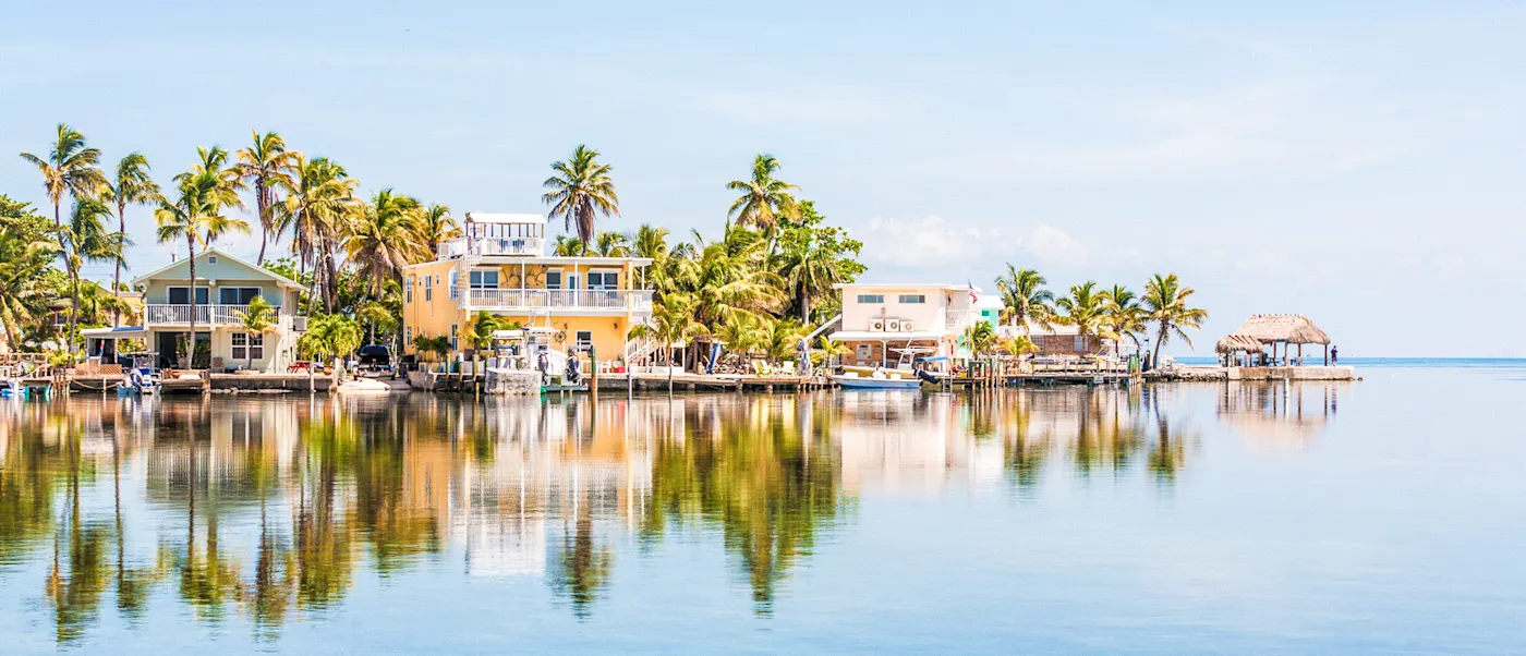 Florida, USA Bunt bemalte Häuser mit Palmen am Ufer einer Bucht in Florida. Florida Keys, Florida, USA.